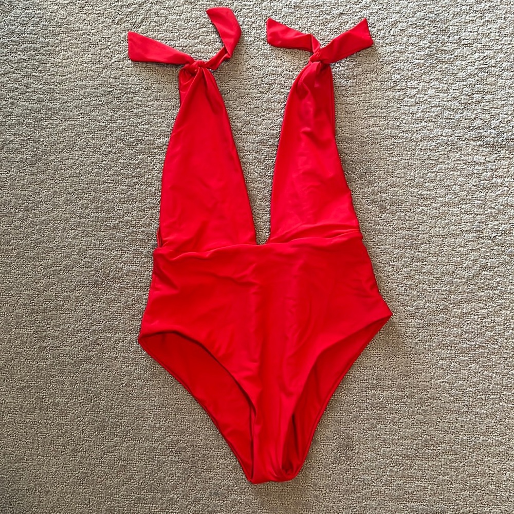 Red plunging one piece swimsuit. Decorative shoulder ties
